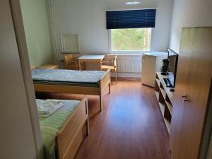 Habitación con 2 camas, escritorio y ventana. en Särkkä, en Äänekoski