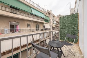 een patio met een tafel en stoelen op een balkon bij Nomad Pennie Home by CloudKeys in Athene