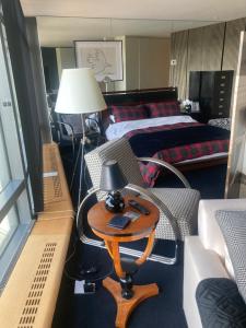 a room with two beds and a table with a lamp at Luxury Designer Apartment River view of Parliament Westminster Big Ben. in London