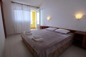 a bedroom with a large bed with two towels on it at Accommodation Salvia in Sveti Juraj