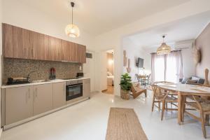 een keuken en een woonkamer met een tafel en een eetkamer bij Nomad Pennie Home by CloudKeys in Athene