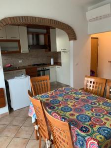 una cucina con tavolo e una tovaglia colorata di CASA AURORA a Porto Santo Stefano
