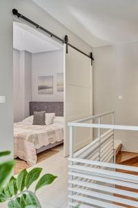 a white bedroom with a bed and a staircase at Old Town Luxury Velvet Apartment in Rhodes Town