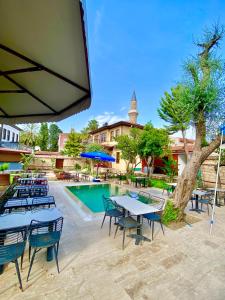 een groep tafels en stoelen naast een zwembad bij Old Town Famous Aparts in Antalya