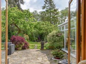a glass door leading into a garden with trees at Kennelmans in Sopley