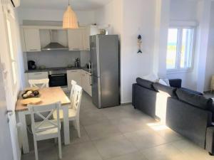 a kitchen and dining room with a table and a refrigerator at Quiet 2-bedroom sea view villa with shared pool in Mármara