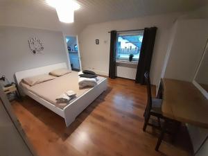 a bedroom with a bed and a table and a window at Haus Konthé, appartement in Winterberg