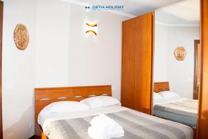 a bedroom with two beds and a mirror at Ostia Holiday Tancredi Chiaraluce in Lido di Ostia