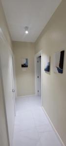 a white hallway with paintings on the walls at Odyssey Allure in Kingston