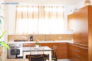 a kitchen with a table and a stove and a window at Ostia Holiday Tancredi Chiaraluce in Lido di Ostia