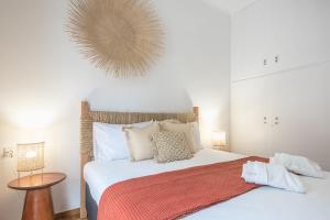een slaapkamer met een groot wit bed en een oranje deken bij Boho Pennie Home by CloudKeys in Athene