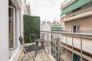 een stoel en een tafel op een balkon bij Boho Pennie Home by CloudKeys in Athene