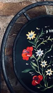 a black plate with flowers painted on it at Casa vacanze Pian di Corte in Belmonte del Sannio