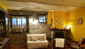 a living room with a chair and a stone fireplace at Casa vacanze Pian di Corte in Belmonte del Sannio