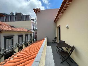 a balcony with a table and chairs on a building at Apartamentos da Carreira in Funchal