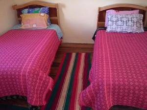 2 Betten nebeneinander in einem Zimmer in der Unterkunft Hostal Luna del Titikaka en Isla de la Luna Bolivia in Isla de la Luna