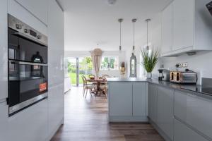 eine Küche mit weißen Schränken und ein Esszimmer in der Unterkunft Luxuriously appointed 3 bedroom cottage off road parking for 3 vehicles dogs welcome by prior arrangement only 3 church cottages Alfrick close to Malvern and Worcester and Shelsley Walsh in a lovely village close to M5 Dogs welcome in Great Malvern