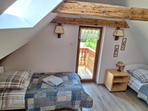 a attic bedroom with two beds and a window at Dom całoroczny JÓZEFINKA w Karkonoszach in Kowary