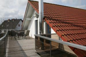 une terrasse en bois avec une table et un toit dans l'établissement FeWo, Ferienwohnung, Peenemünde im Naturschutzgebiet, à Peenemünde