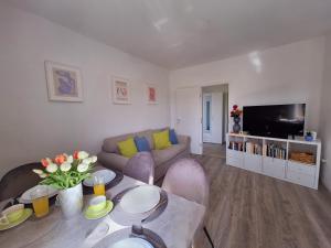 sala de estar con sofá y TV en Apartment Ivy en Mlini