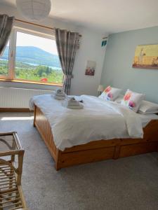 una camera da letto con un grande letto con una grande finestra di Grenane Heights a Kenmare