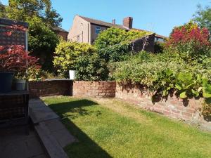 a garden with a brick wall and some plants at Holland House in New Brighton