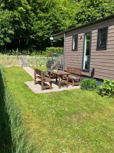 einem Picknicktisch und Bänken vor einer Hütte in der Unterkunft Spatzennest Beach Chalet 22 in Scharbeutz