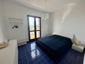 a bedroom with a blue bed and a window at Finestra sul mare in Agrigento