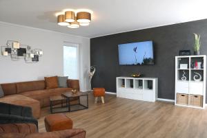 sala de estar con sofá y TV en la pared en Die Herberge en Rechlin