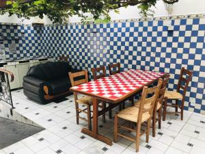 einen Tisch und Stühle auf einer Terrasse mit einem karierten Boden in der Unterkunft Chapadão Hostel in Lençóis