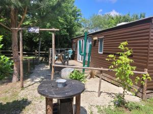 a picnic table in front of a tiny house at Camping Syl-Vallée Western Village in Bouglon