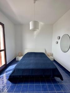 a bedroom with a large blue bed in a room at Finestra sul mare in Agrigento