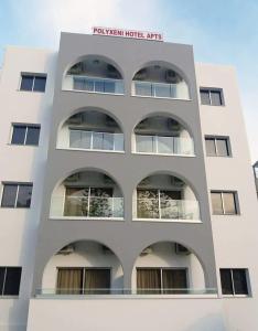 un grand bâtiment blanc avec un panneau sur celui-ci dans l'établissement Polyxeni Hotel Apartments, à Limassol