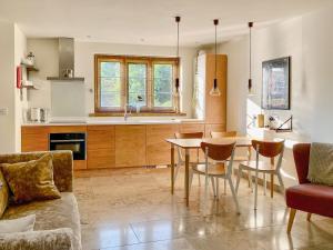 cocina y sala de estar con mesa y sillas en Finch Cottage, en Farnborough