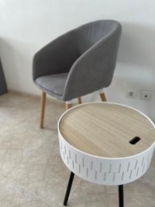 a gray chair and a table in a room at Alojamento Ramos in Quarteira +19 photos