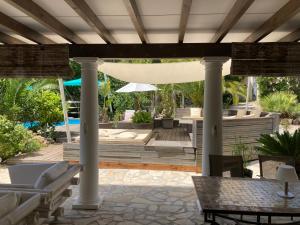 a pavilion with a table and chairs on a patio at Villa Sanssoucis Les Issambres in Les Issambres
