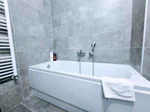 蒂米什瓦拉的住宿－ATENEO - Studio DeLuxe Modern Apartment, Big Balcony, Plus Parking，浴室设有白色浴缸,铺有瓷砖。