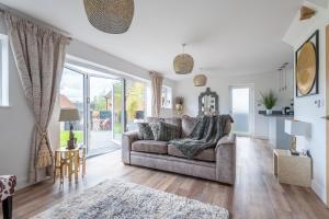 a living room with a couch and a large window at Luxurious 3 bedroom house Shangri la in village of Alfrick with free off road parking for 3 cars in an area of outstanding natural beauty, superb walking,close to Worcester, Malvern showground, theatre, Malvern hills, dogs welcome in Worcester