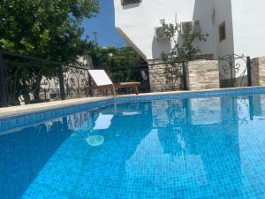 a large blue swimming pool next to a building at Hotel Gjirokastra in Gjirokastër