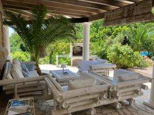 a patio with couches and chairs under a pergola at Villa Sanssoucis Les Issambres in Les Issambres