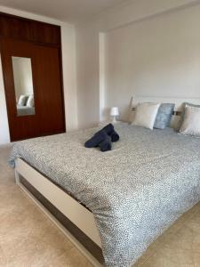 a stuffed animal sitting on a bed in a bedroom at Alojamento Ramos in Quarteira