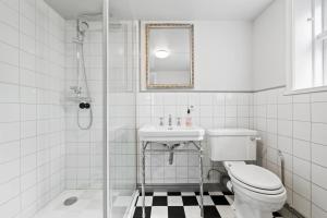 a bathroom with a toilet and a sink and a shower at Downtown Baldursbrá Holiday Home in Reykjavík