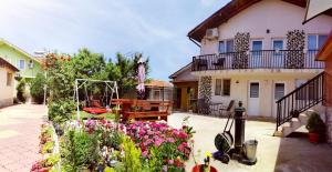 a garden with flowers in front of a house at Casa Georgeta 2 Mai-Punct Gastronomic Local-AROME DOBROGENE in 2 Mai