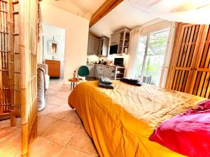 ein Schlafzimmer mit einem großen Bett in einem Zimmer in der Unterkunft Charmant logement provençal avec piscine à deux pas du village médieval in Seillans