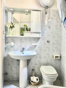 a bathroom with a sink and a toilet and a mirror at Dimora Galerana, Oria città del Salento in Oria