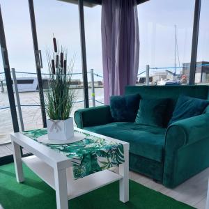 a living room with a couch and a table at ARKA 2 domki na wodzie w Mielnie 400 metrów do morza, rower wodny, Wifi, Parking in Mielno +74 photos