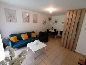 a living room with a blue couch and a table at Détent'Appart Proche Quais in Canteleu