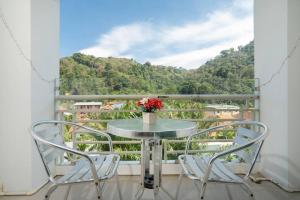 - une table avec un vase de fleurs sur le balcon dans l'établissement Private Rooftop Pool - Penthouse, à Phuket