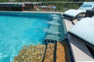 een zwembad met blauw water en 2 stoelen bij Private Rooftop Pool - Penthouse in Phuket