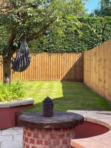 a garden with a fence and a table with an umbrella at Hound and Human Holiday Cottage - Redgrave, Suffolk in Diss